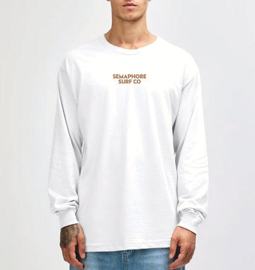 Model wearing the white Semaphore Surf Co. emblem long sleeve tee, front view with the wordmark on the chest